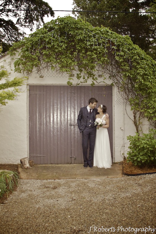 Bride and groom together outside barn - wedding photography